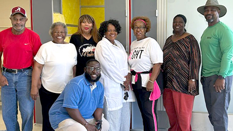 A group of people standing in front of the Boligee OnMed Care Station.