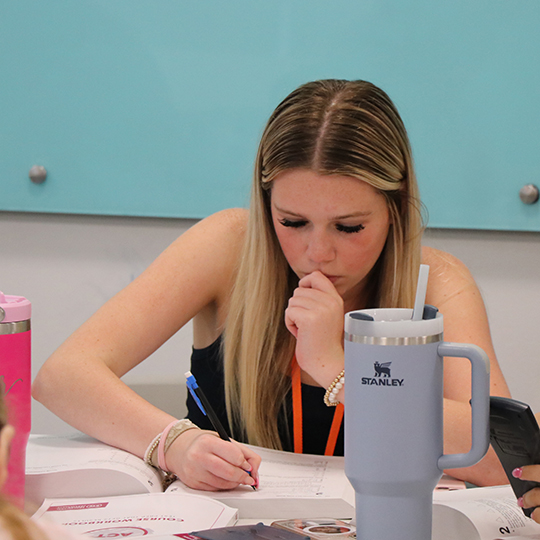 Girl writing in a book.