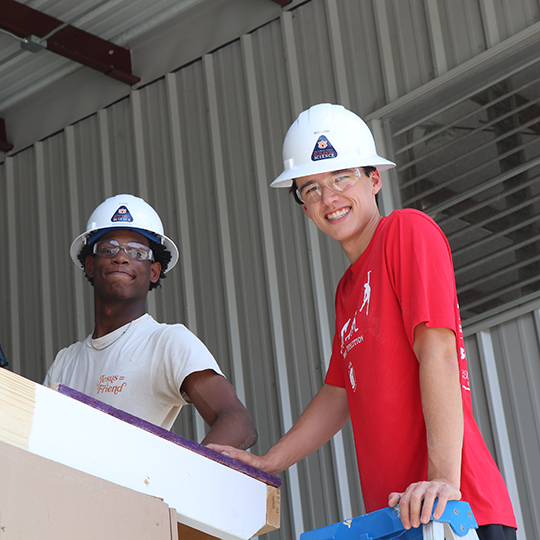 Two male students wearing hard hats