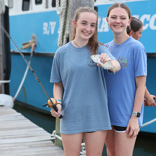 2 Girls holding a fish.