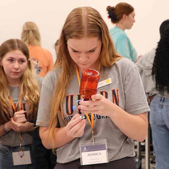 Femail student measuring out liquid medication