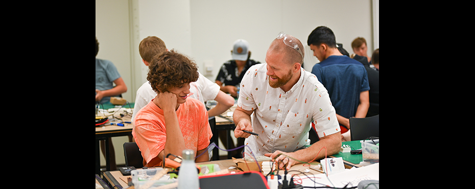 Instructor and student at a work table