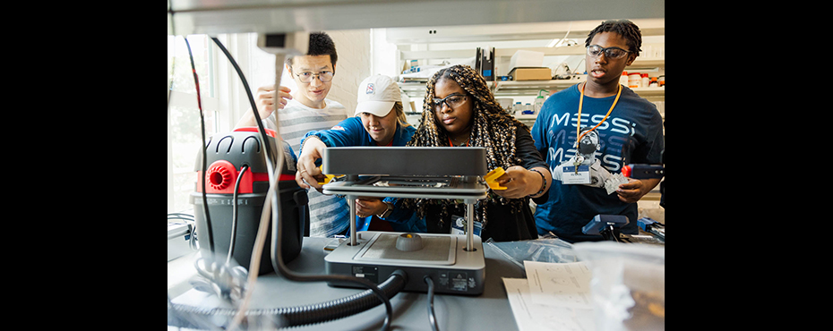 Students using an injection molding device