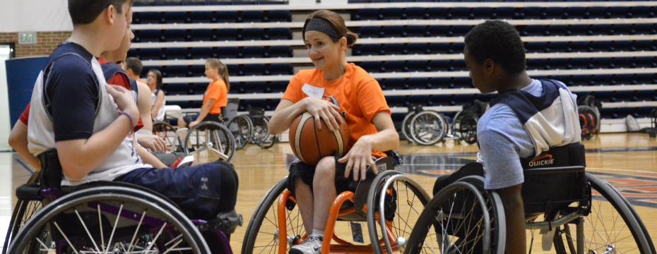 A group of Wheelchair basketball campers discuss plays during their break at camp.