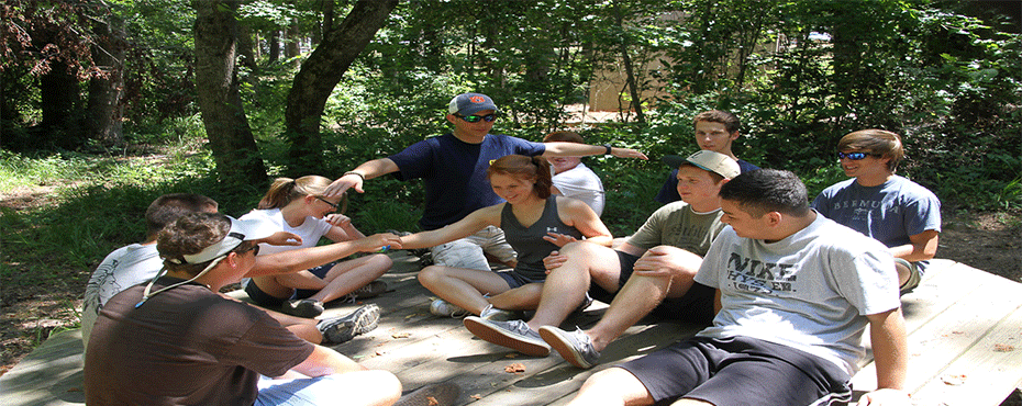 People participate in a group discussion at the challenge course.