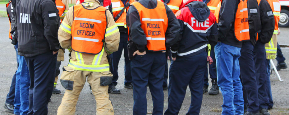 Emergency Personnel huddled in a circle during a meeting.