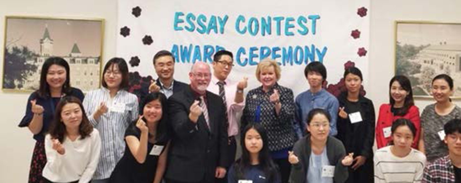 Large group in front of essay contest sign