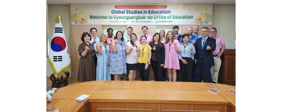 Group photo of all men and women participants, Global Studies in Education Welcome and Korean flag to the left.