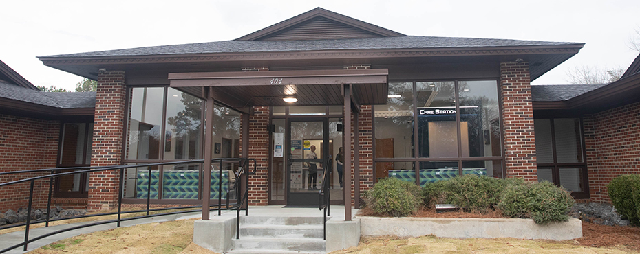 Exterior image of the Center includes glass windows with visual of lit telehealth station