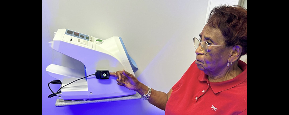 A community member from Sumter County utilizing the CareStation in the Gainesville Municipal Complex to take her vitals, specifically her oxygen levels. 