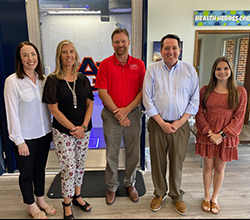 Caroline Straton, Rodney Granec, and Christopher Theriot from UWA along with Hollie Cost and Mikailie Caulder from Auburn University standing in front of the Chambers County OnMed Care Station